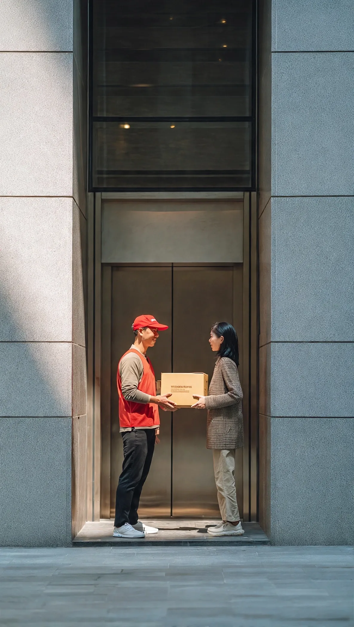 A resident receiving a delivery from a courier at her condo lift lobby